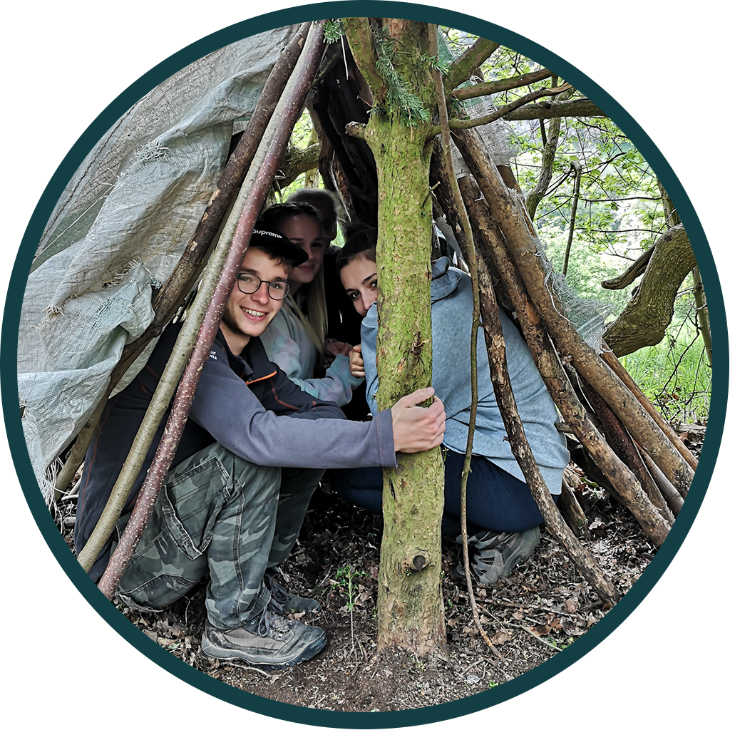 Group of teens in a makeshift shelter in the woods